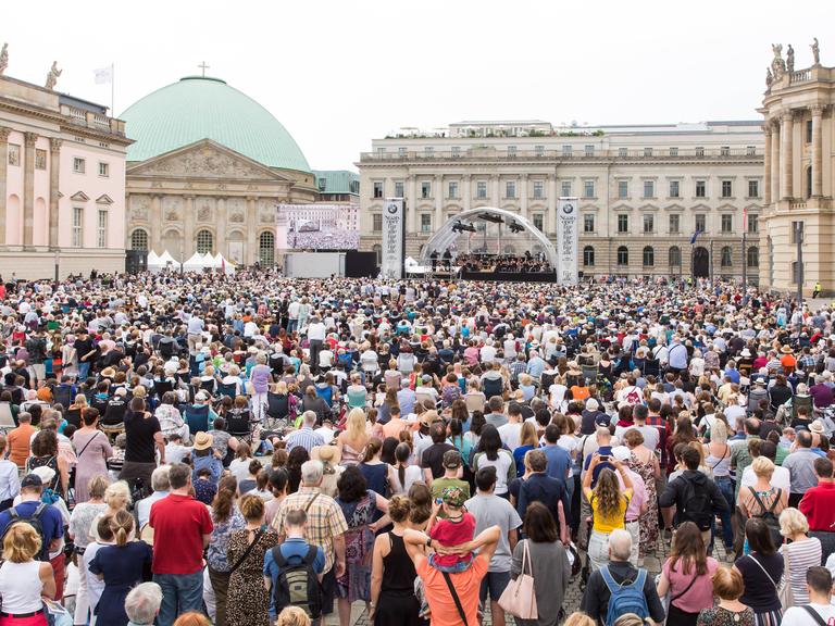 Blick auf den Bebelplatz in Berlin, wo viele Menschen einem Konzert zuhören