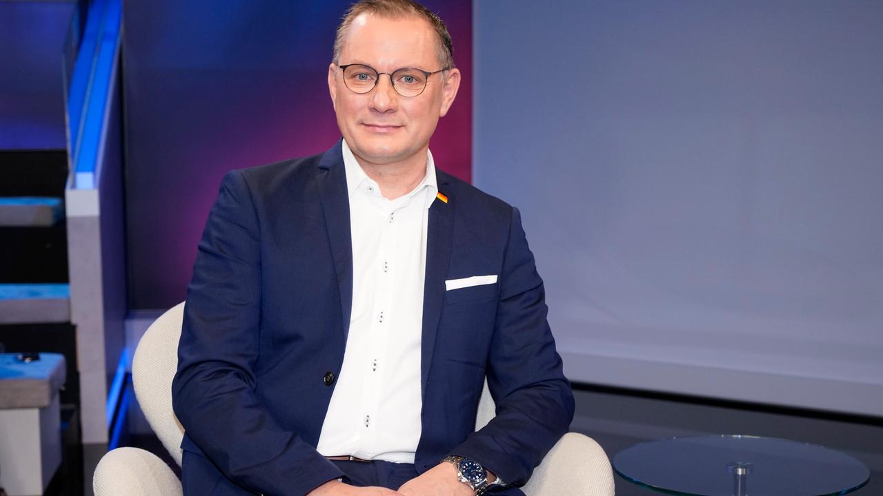Der AfD-Bundestagsabgeordnete und Co-Bundessprecher Tino Chrupalla sitzt im Januar 2024 in einem Sessel im Studio einer TV-Talkshow und schaut in die Kamera. 