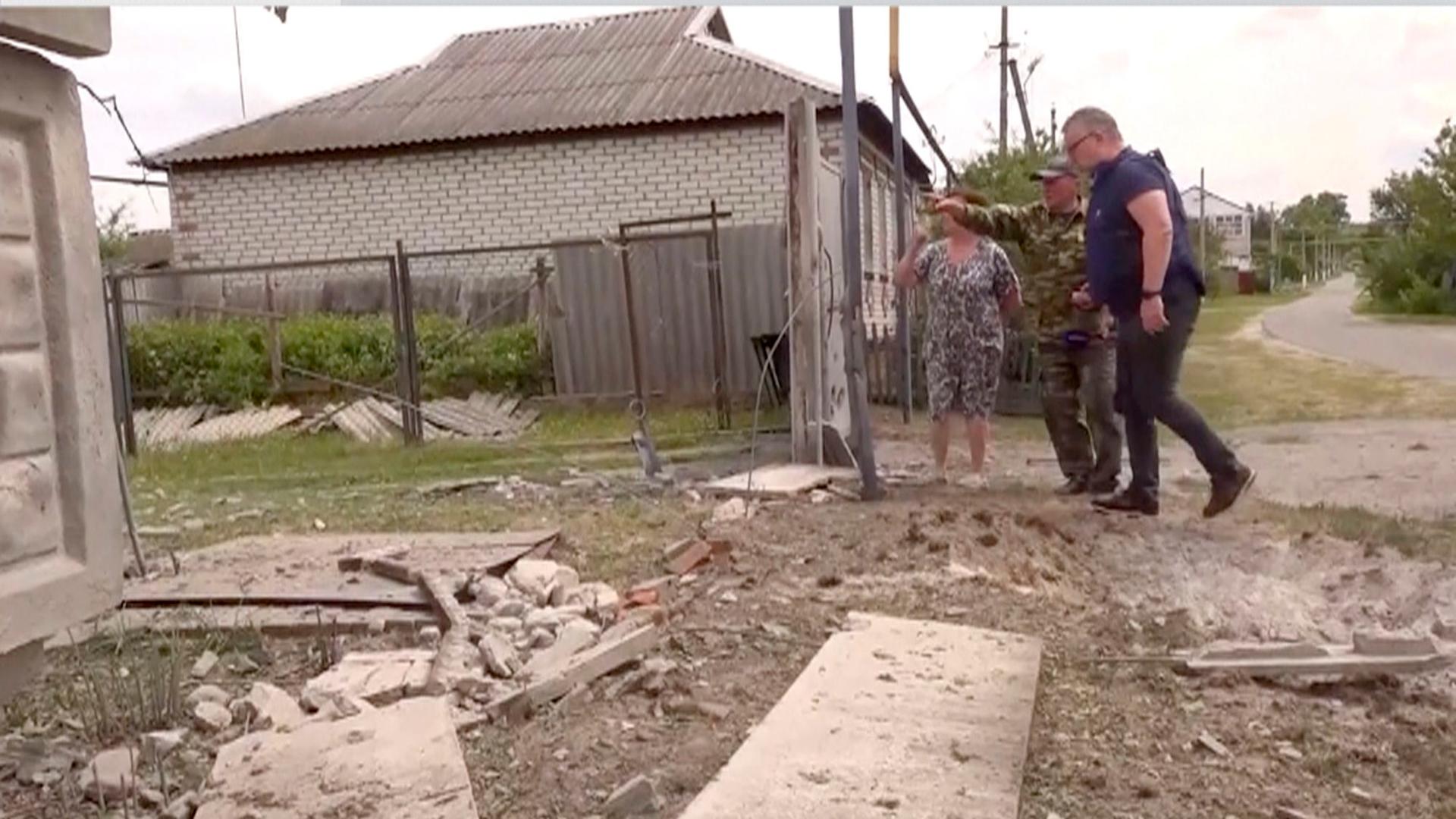 Russland, Belgorod: Personen begutachten ein zerstörtes Haus.