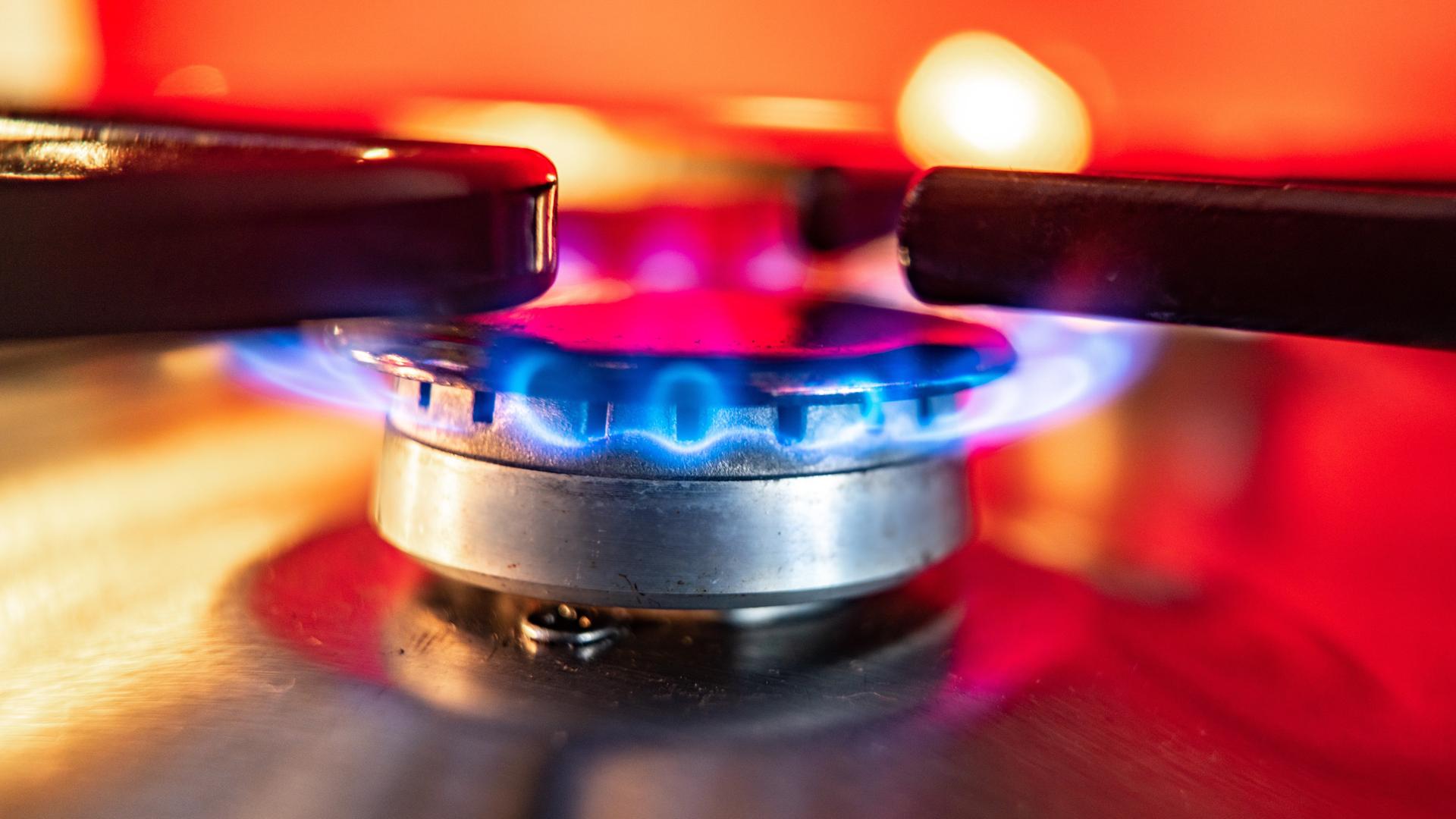 Eine Gasflamme brennt auf einem Küchenherd. Eine Gasflamme brennt auf einem Küchenherd.