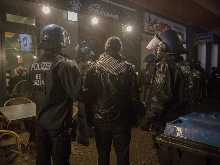 Ein Mann mit Palästinensertuch zwischen zwei deutschen Polizisten im Berliner Stadtteil Neukölln. 7. Oktober 2023.
