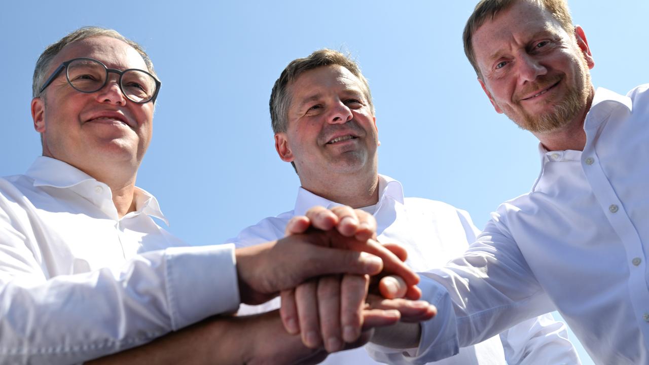 Mario Voigt (CDU), Ministerpräsident von Thüringen, Sven Schulze (CDU), Ministerpräsident von Sachsen-Anhalt, und Michael Kretschmer (CDU), Ministerpräsident von Sachsen legen ihre Hände übereinander.