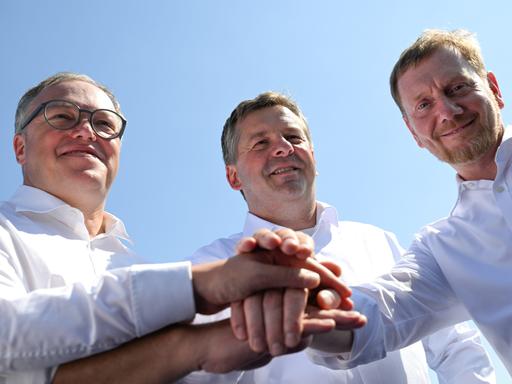 Mario Voigt (CDU), Ministerpräsident von Thüringen, Sven Schulze (CDU), Ministerpräsident von Sachsen-Anhalt, und Michael Kretschmer (CDU), Ministerpräsident von Sachsen legen ihre Hände übereinander. Mario Voigt (CDU), Ministerpräsident von Thüringen, Sven Schulze (CDU), Ministerpräsident von Sachsen-Anhalt, und Michael Kretschmer (CDU), Ministerpräsident von Sachsen legen ihre Hände übereinander.