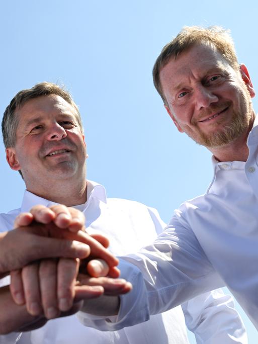 Mario Voigt (CDU), Ministerpräsident von Thüringen, Sven Schulze (CDU), Ministerpräsident von Sachsen-Anhalt, und Michael Kretschmer (CDU), Ministerpräsident von Sachsen legen ihre Hände übereinander. Mario Voigt (CDU), Ministerpräsident von Thüringen, Sven Schulze (CDU), Ministerpräsident von Sachsen-Anhalt, und Michael Kretschmer (CDU), Ministerpräsident von Sachsen legen ihre Hände übereinander.