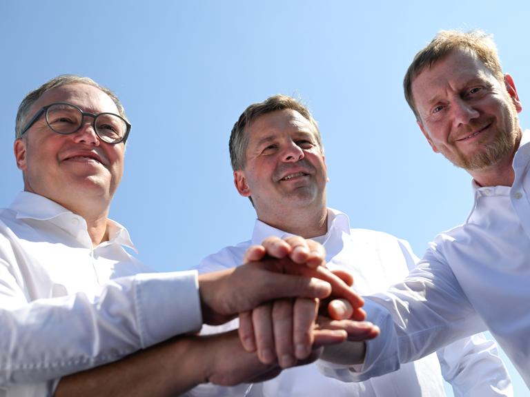 Mario Voigt (CDU), Ministerpräsident von Thüringen, Sven Schulze (CDU), Ministerpräsident von Sachsen-Anhalt, und Michael Kretschmer (CDU), Ministerpräsident von Sachsen legen ihre Hände übereinander. Mario Voigt (CDU), Ministerpräsident von Thüringen, Sven Schulze (CDU), Ministerpräsident von Sachsen-Anhalt, und Michael Kretschmer (CDU), Ministerpräsident von Sachsen legen ihre Hände übereinander.