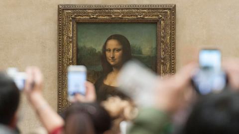 Viele Menschen tummeln sich um die Mona Lisa im Louvre: Aufgrund der vielen Smartphones, die die Leute hochhalten, ist das berühmte Bild kaum zu erkennen.