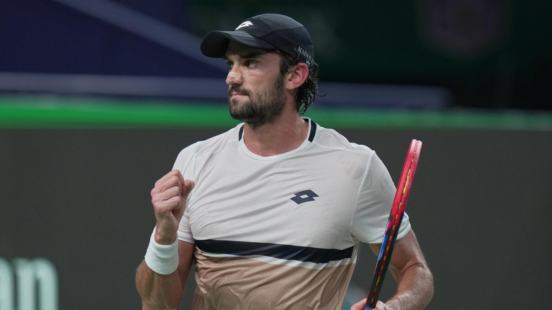 Valentin Vacherot steht gegen Novak Djokovic auf dem Tennisplatz. Er ballt die Faust und freut sich über einen gemachten Punkt. Valentin Vacherot steht gegen Novak Djokovic auf dem Tennisplatz. Er ballt die Faust und freut sich über einen gemachten Punkt.