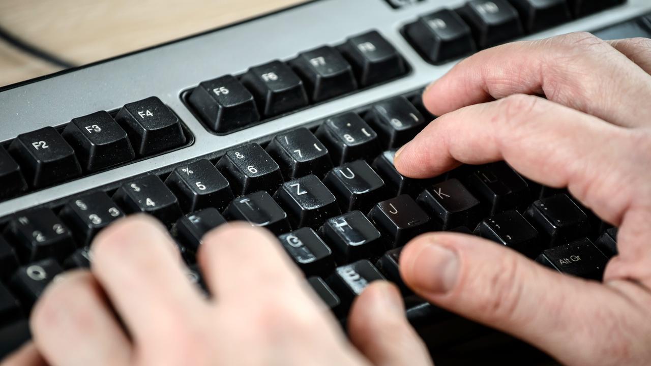 Ein Mann tippt auf der Tastatur eines Computers