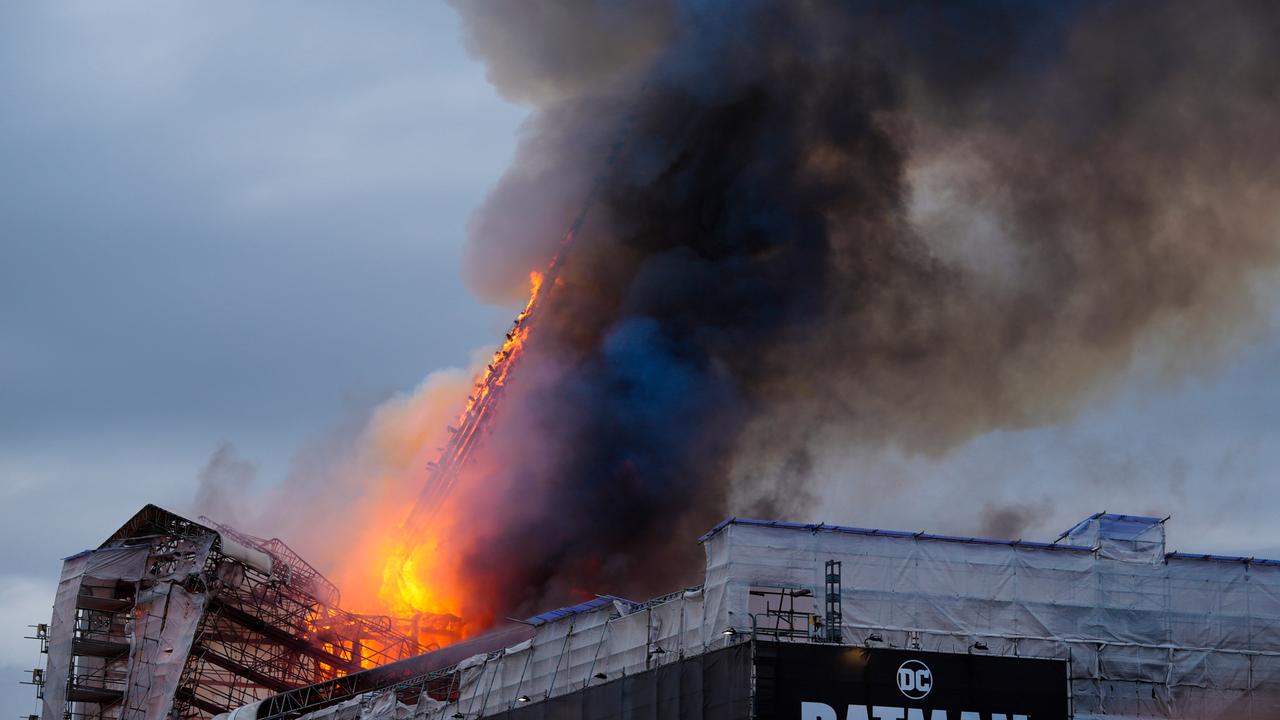 Die eingerüstete historischen Börse in Kopenhagen steht in Flammen. Man sieht auch die brennende und abknickende Turmspitze.