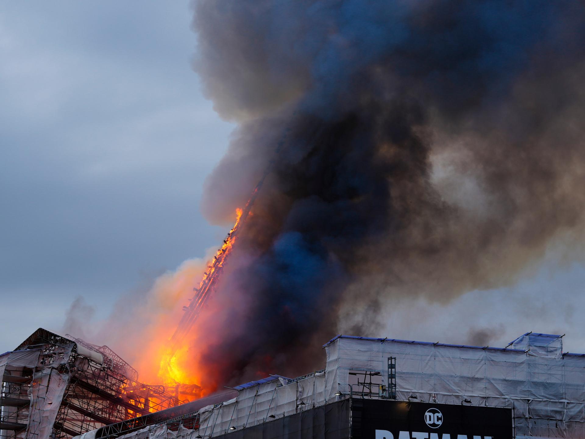 Die eingerüstete historischen Börse in Kopenhagen steht in Flammen. Man sieht auch die brennende und abknickende Turmspitze. 