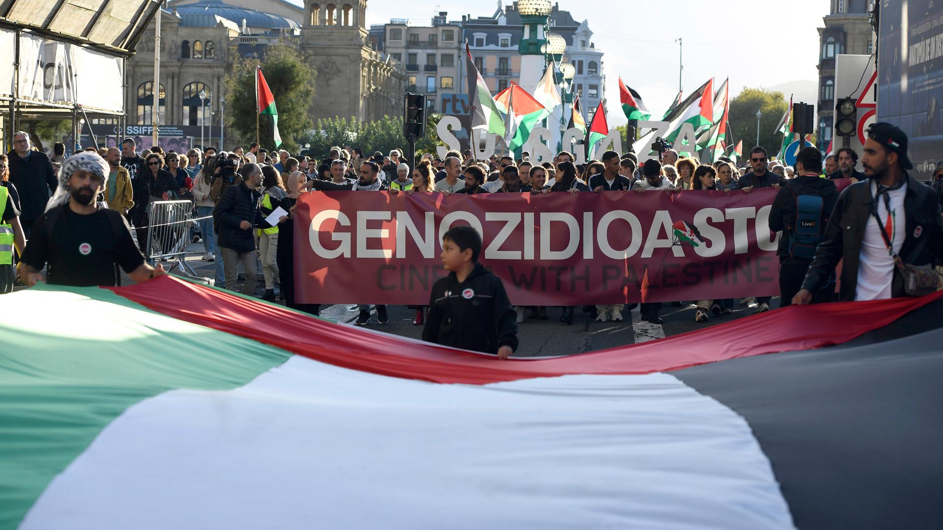 "Stoppt den Genozid" steht in etwa auf dem Banner, das Demonstrierende vor sich hertragen. auf dem 73. Internationalen Filmfestival San Sebastian / Festival Internacional de Cine de San Sebastián. San Sebastian, 24.09.2025