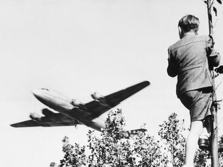 Ein Junge verfolgt von einem Baum aus den Landeanflug eines US-amerikanischen Transportflugzeugs auf den Berliner Flughafen Tempelhof. Ein Junge verfolgt von einem Baum aus den Landeanflug eines US-amerikanischen Transportflugzeugs auf den Berliner Flughafen Tempelhof.