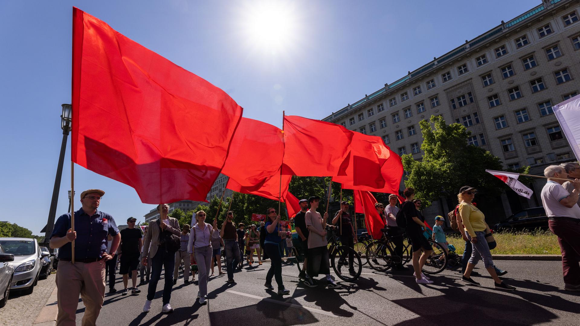 Demonstranten laufen mit rote Flaggen durch eine Stadt. Demonstranten laufen mit rote Flaggen durch eine Stadt.