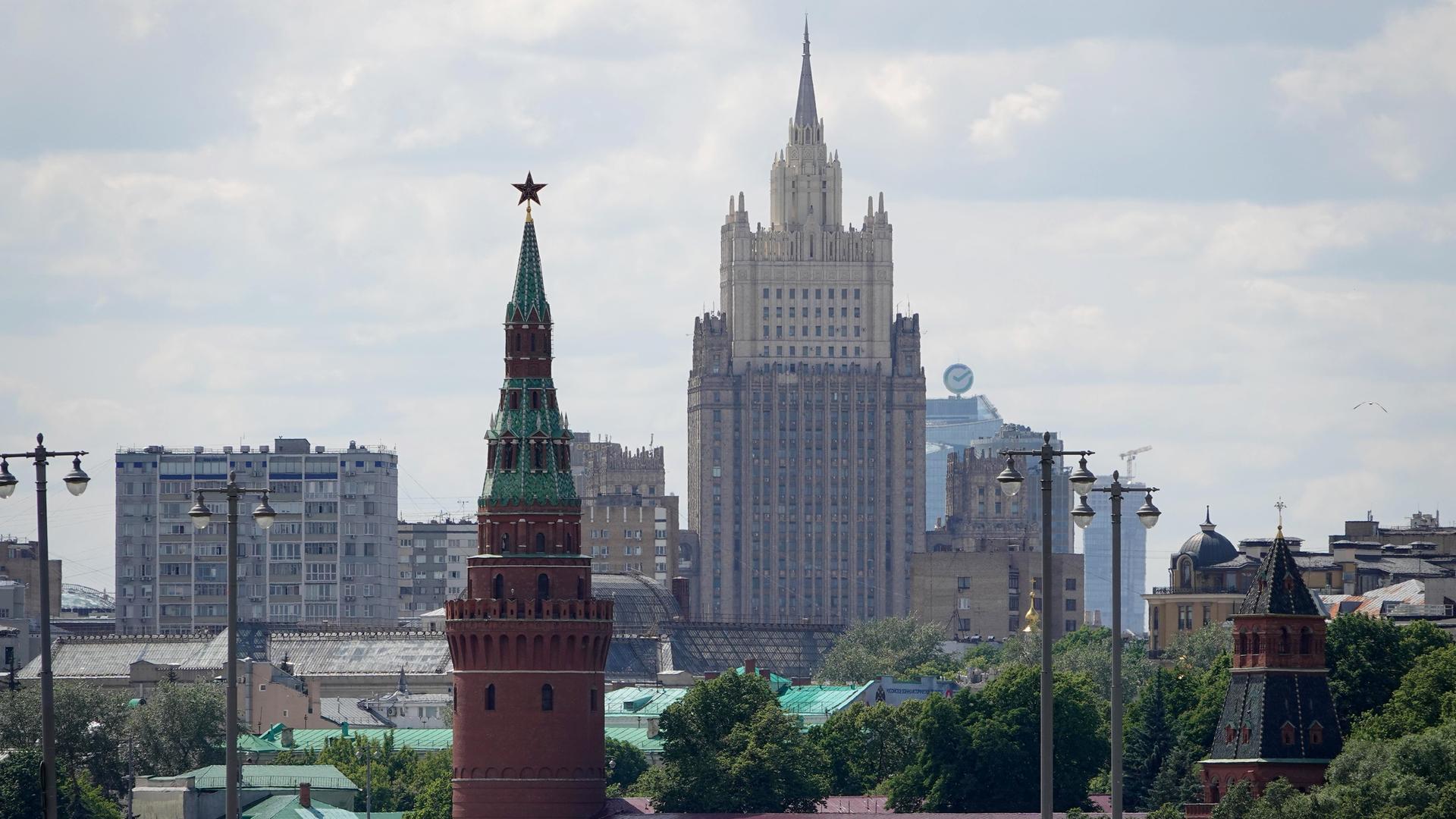 Ein Wachtum des Kreml (l) und das Außenministerium (M, Hintergrund) stehen im Zentrum der russischen Hauptstadt Moskau.