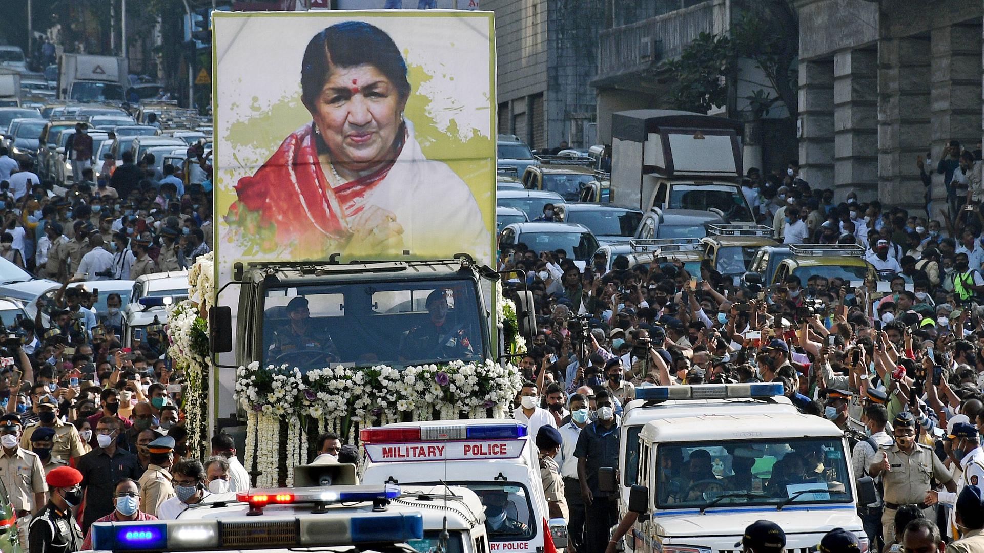 Ein Trauerzug, auf einem Auto ist ein sehr großes Bild von Lata Mangeshkar montiert. Ein Trauerzug, auf einem Auto ist ein sehr großes Bild von Lata Mangeshkar montiert.