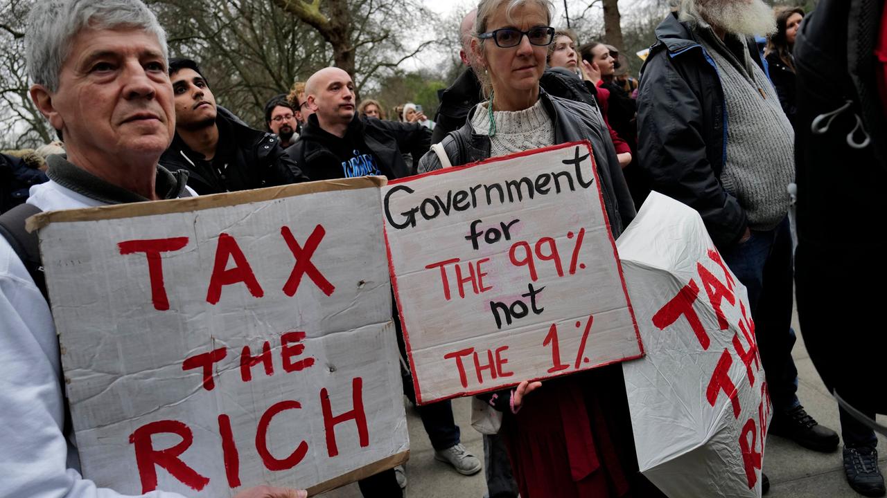 Londoner Demonstrierende halten Schilder mit der Aufschrift "Tax the rich" und"Government for the 99% not the 1%". social and economic justice. Kein Aufnahmedatum.