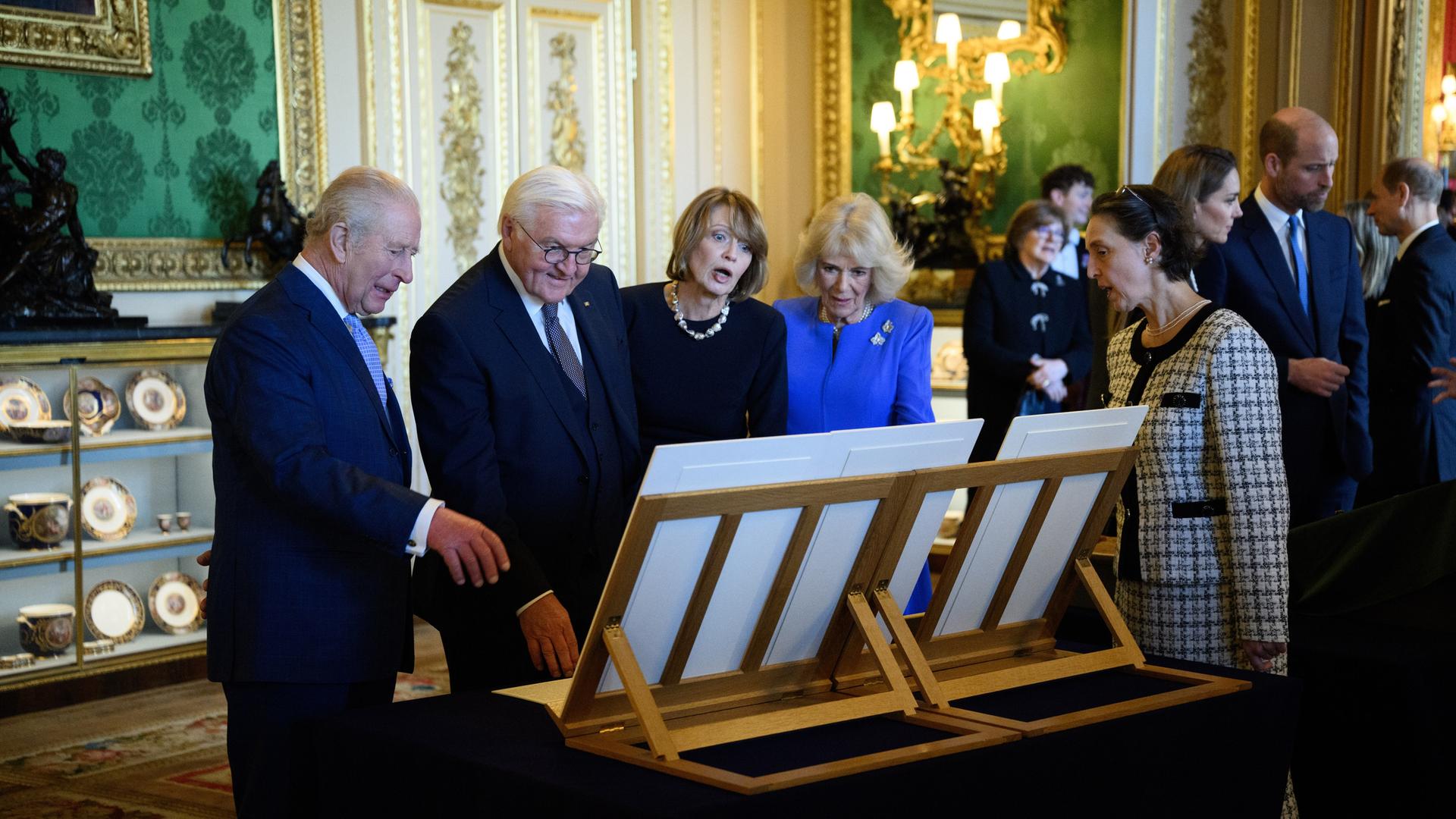 Bundespräsident Frank-Walter Steinmeier (2.v.l) und seiner Frau Elke Büdenbender (M) werden von König Charles III. (l) und Königin Camilla im Schloss Windsor besondere Objekte aus der Königlichen Sammlung präsentiert.