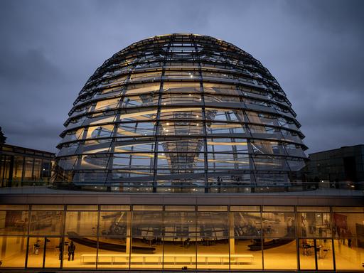 Die Kuppel des Reichstagsgebäudes wird am Morgen erleuchtet. 