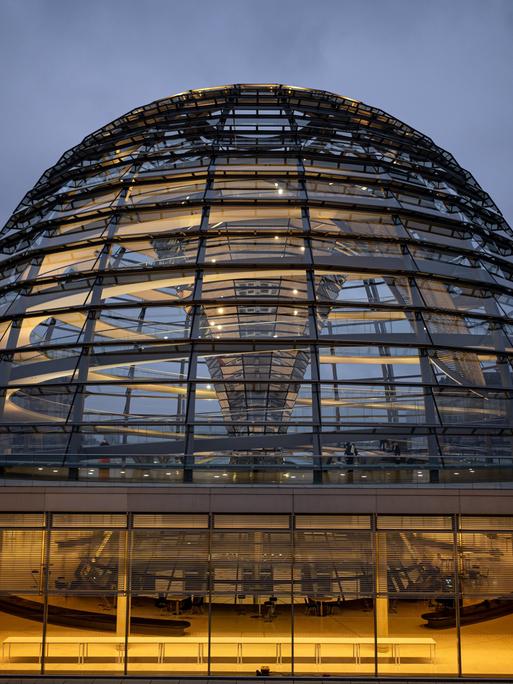 Die Kuppel des Reichstagsgebäudes wird am Morgen erleuchtet. 