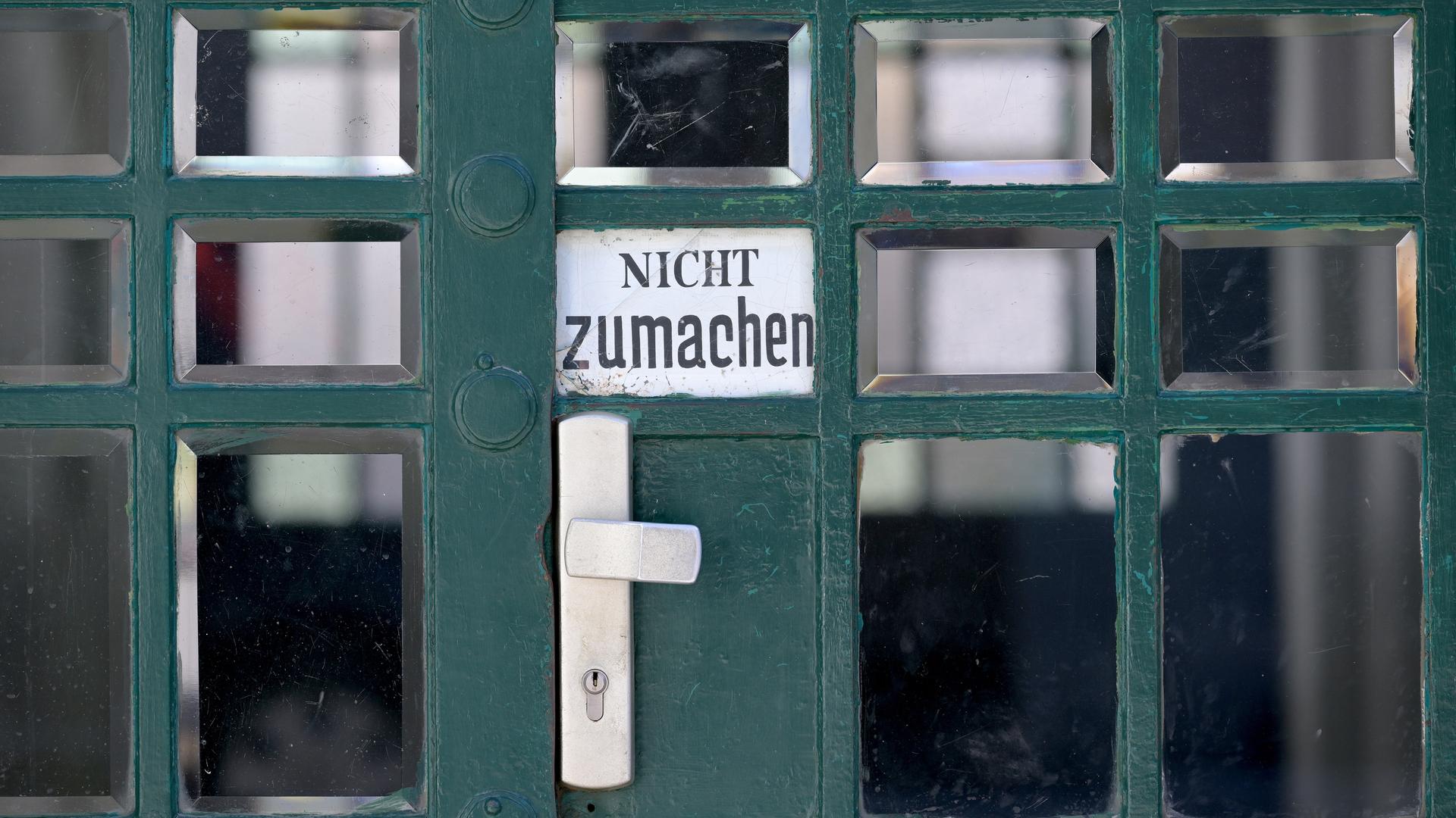 An einer Tür hängt ein Schild, auf dem "Nicht zumachen" steht.
