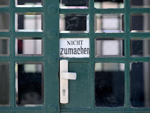An einer Tür hängt ein Schild, auf dem "Nicht zumachen" steht.
