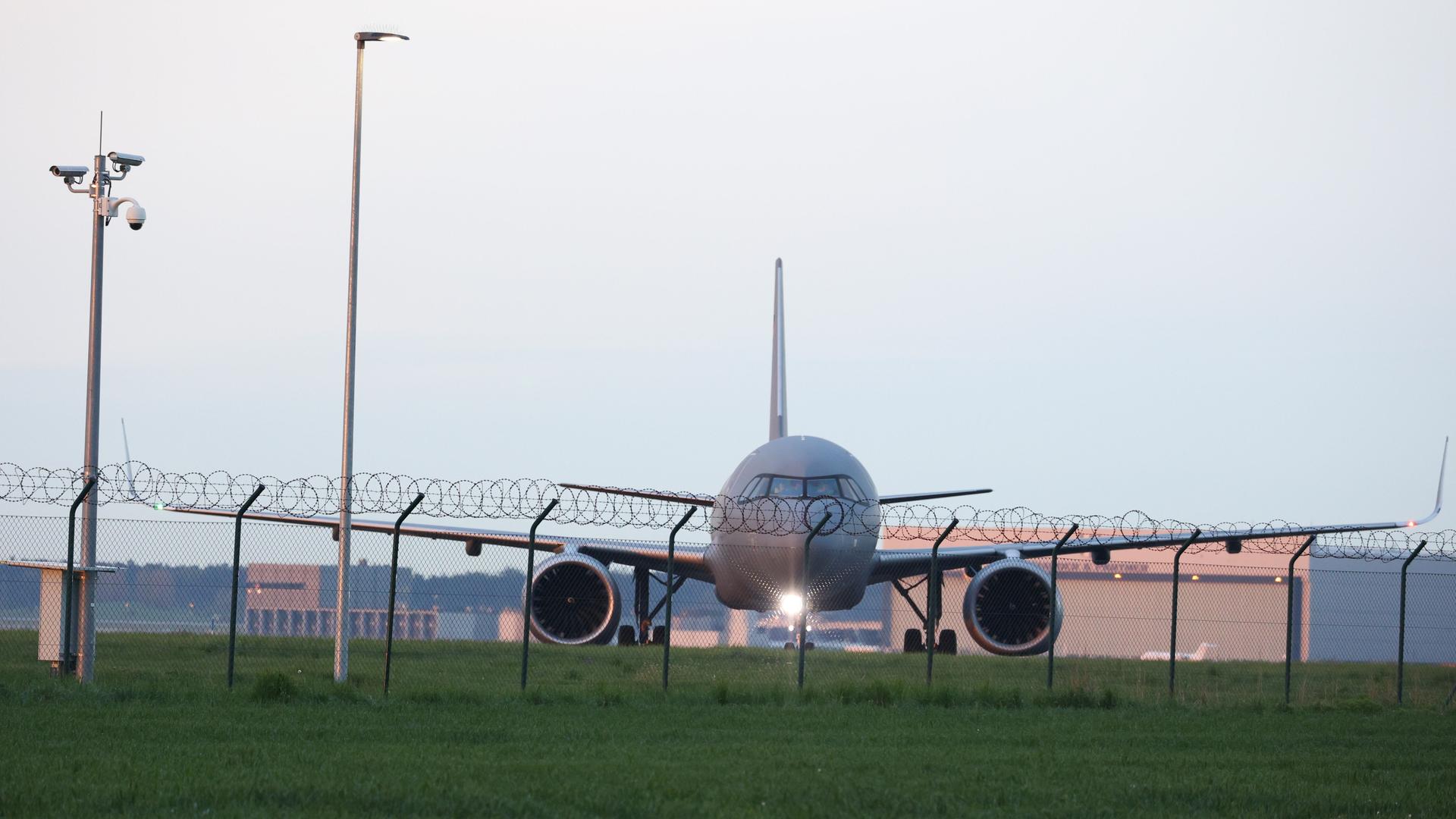 Ein Flugzeug hinter Stacheldraht am Flughafen BER