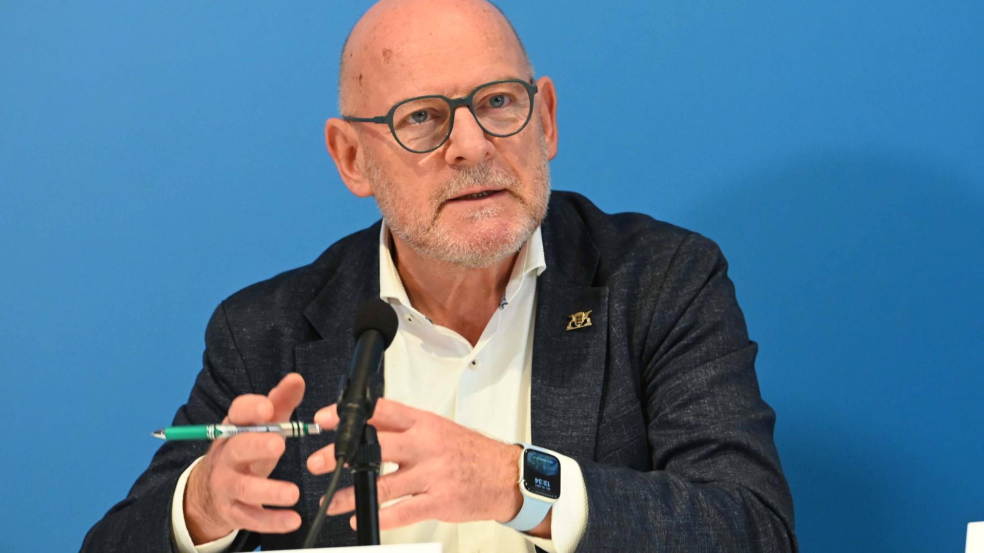 Winfried Hermann, Verkehrsminister von Baden-Württemberg, spricht, an einem Tisch sitzend und gestikuliert dabei mit den Händen.