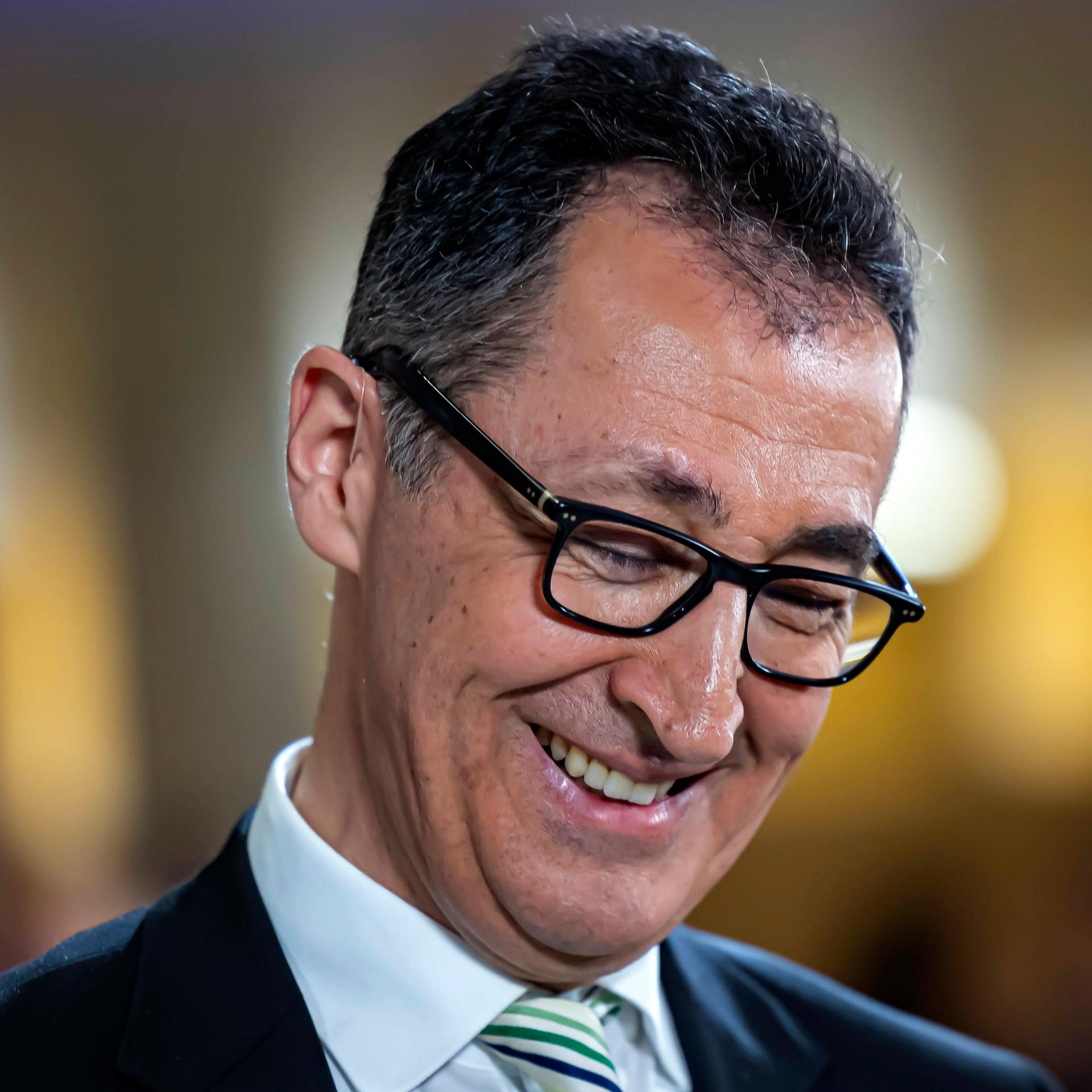 Cem Özdemir, Grüne, lächelt und schaut dabei nach unten. 