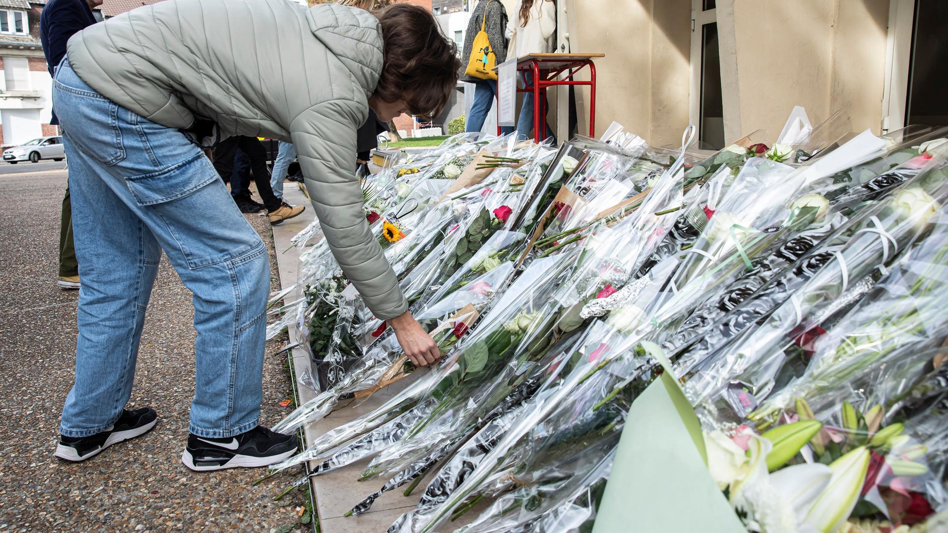 Vor einer Schule im französischen Arras liegen zahlreiche Blumen. Drei Tage zuvor war dort ein Lehrer bei einem Attentat ums Leben gekommen. (Aufgenommen am 16.10.2023) 