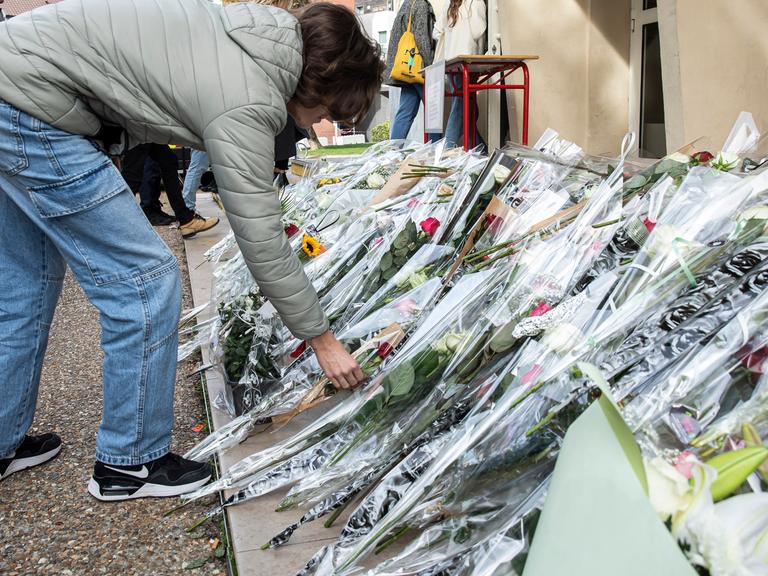 Vor einer Schule im französischen Arras liegen zahlreiche Blumen. Drei Tage zuvor war dort ein Lehrer bei einem Attentat ums Leben gekommen. (Aufgenommen am 16.10.2023) 