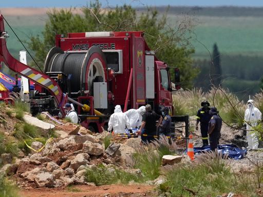 Gerichtsmediziner tragen Leichen in blauen Säcken bei einer Rettungsaktion. Bergung von Bergleuten aus einer verlassenen Goldmine in Stilfontein, Südafrika, 15. Januar 2025. 