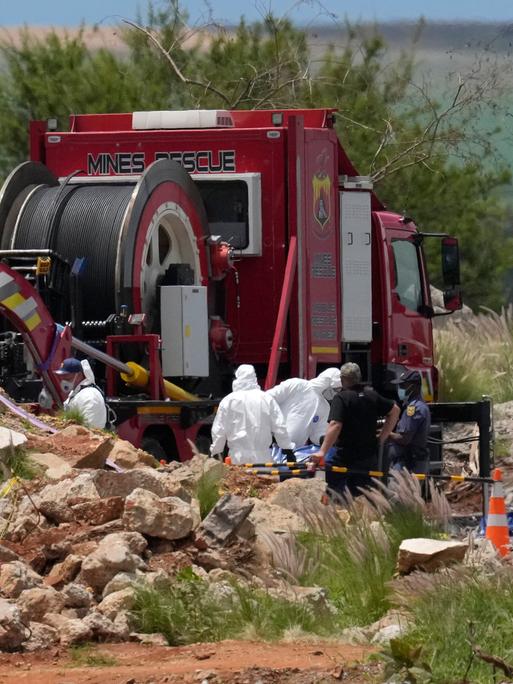Gerichtsmediziner tragen Leichen in blauen Säcken bei einer Rettungsaktion. Bergung von Bergleuten aus einer verlassenen Goldmine in Stilfontein, Südafrika, 15. Januar 2025. 