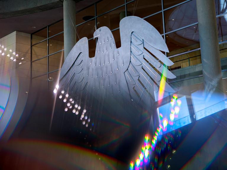 Der Bundesadler mit Lichtreflektionen im Plenarsaal des Deutschen Bundestages