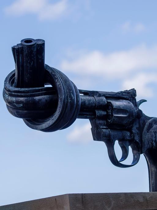 Eine Skulptur symbolisiert einen Revolver. Dessen Lauf sist zu einem Knoten verbogen. Die Skulptur steht vor dem Hauptgebäude der Vereinten Nationen in New York. Eine Skulptur symbolisiert einen Revolver. Dessen Lauf sist zu einem Knoten verbogen. Die Skulptur steht vor dem Hauptgebäude der Vereinten Nationen in New York.