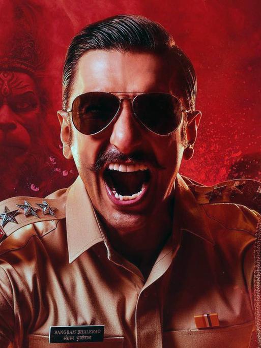 Ein Schauspieler als Polizist auf einem Werbemotiv für den indischen Film "Singham Again" von Rohit Shetty Ranveer Singh. 