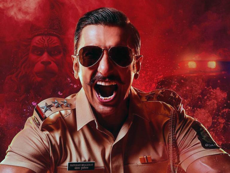 Ein Schauspieler als Polizist auf einem Werbemotiv für den indischen Film "Singham Again" von Rohit Shetty Ranveer Singh. 