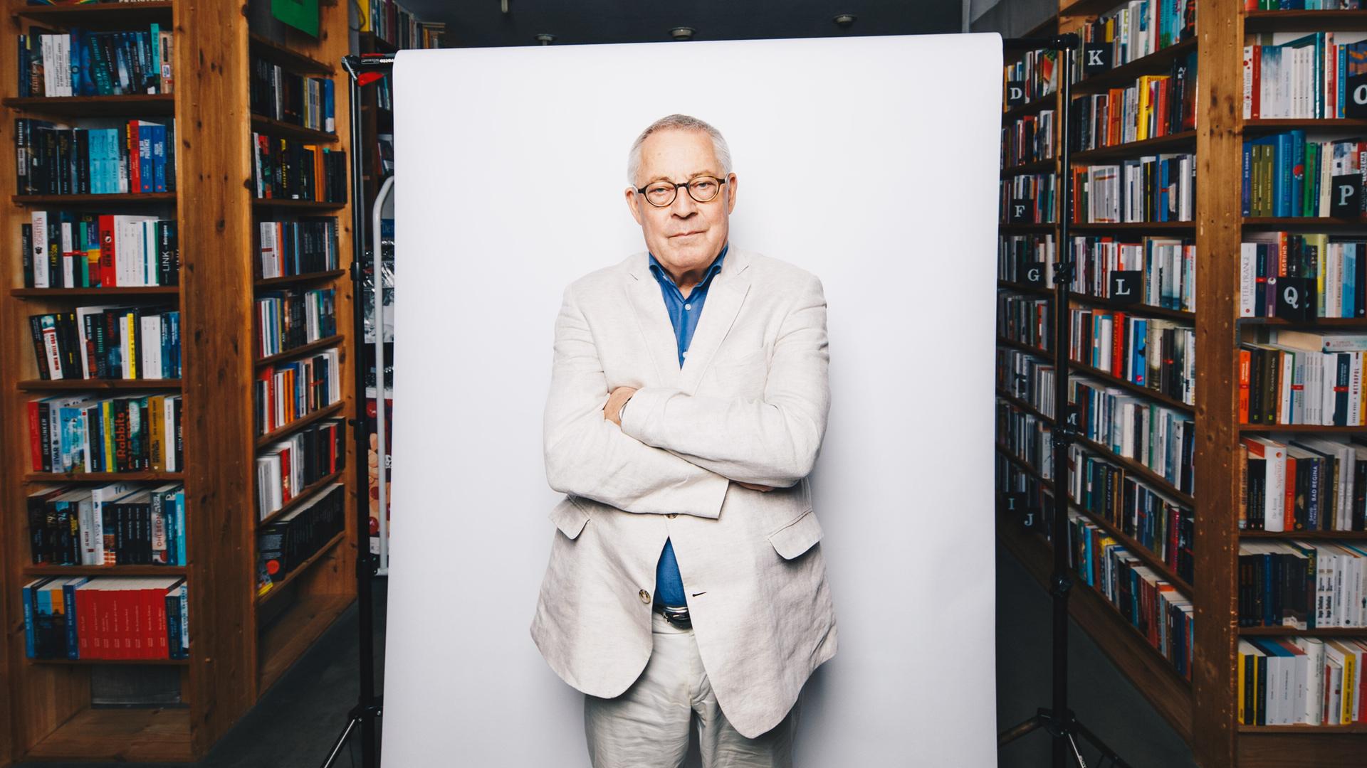 Der Autor Karl Schlögel posiert vor weißer Hintergrundaufhängung in der Buchhandlung am Bayrischen Platz in Berlin.