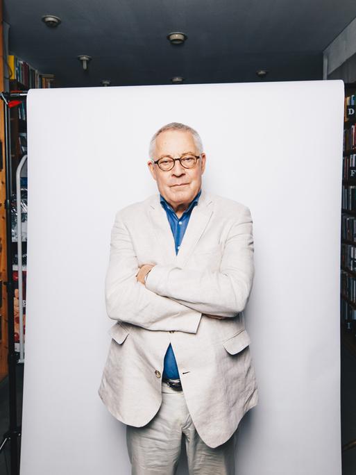 Der Autor Karl Schlögel posiert vor weißer Hintergrundaufhängung in der Buchhandlung am Bayrischen Platz in Berlin.