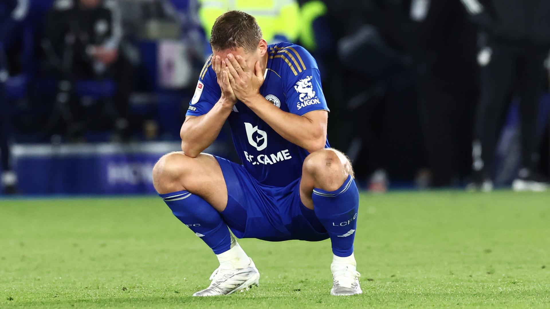 Fußballspieler Jannik Vestergaard von Leicester City sitzt in der Hocke und schlägt die Hände vors Gesicht. 