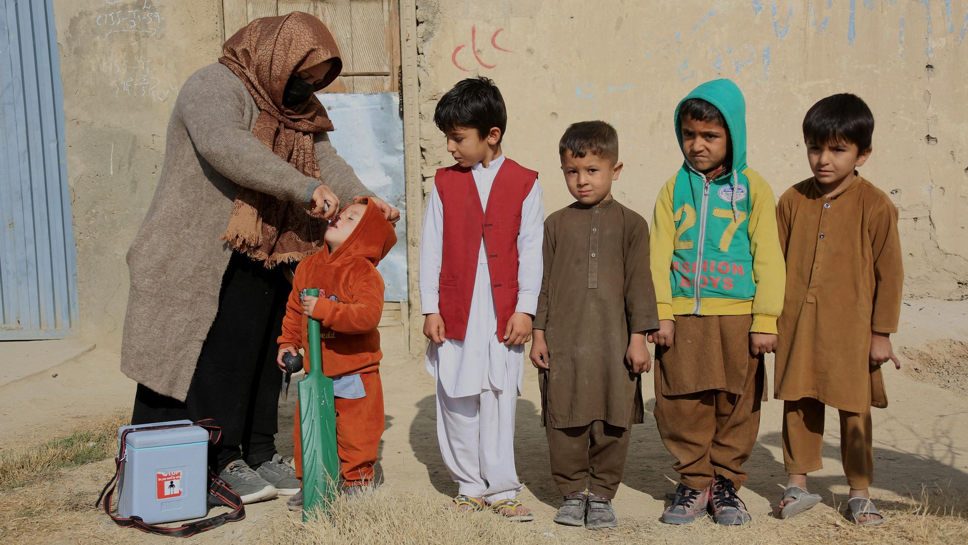 Eine Gesundheitsmitarbeiterin gibt Kindern Impfdosen gegen Polio.