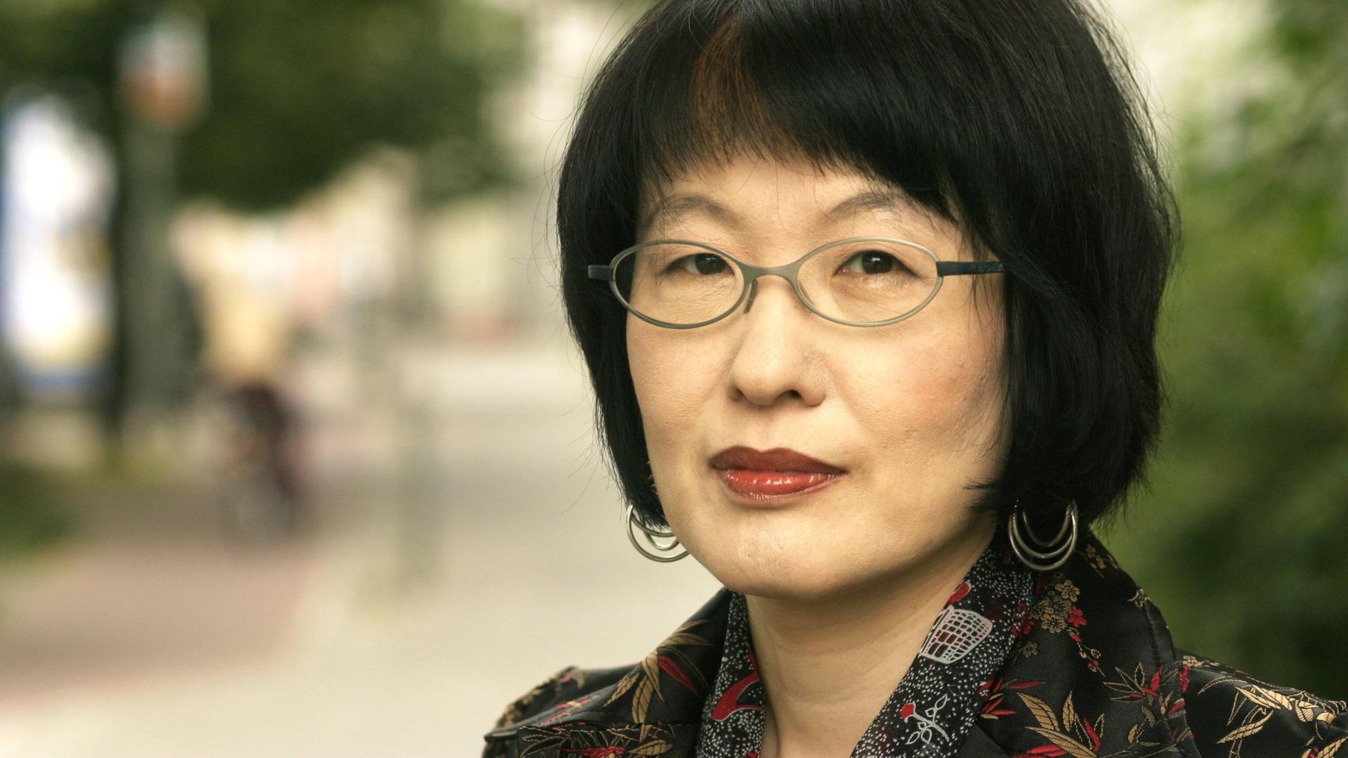 Kim Hyesoon auf einem Foto von 2005. Die Lyrikerin aus Südkorea steht im Freien und schaut in die Kamera.