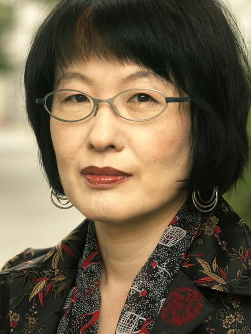 Kim Hyesoon auf einem Foto von 2005. Die Lyrikerin aus Südkorea steht im Freien und schaut in die Kamera.