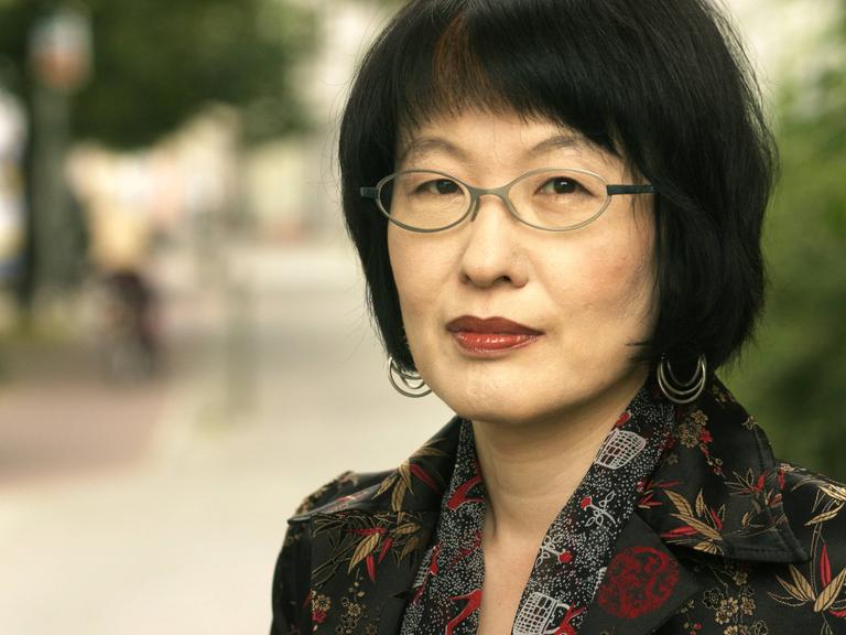 Kim Hyesoon auf einem Foto von 2005. Die Lyrikerin aus Südkorea steht im Freien und schaut in die Kamera.
