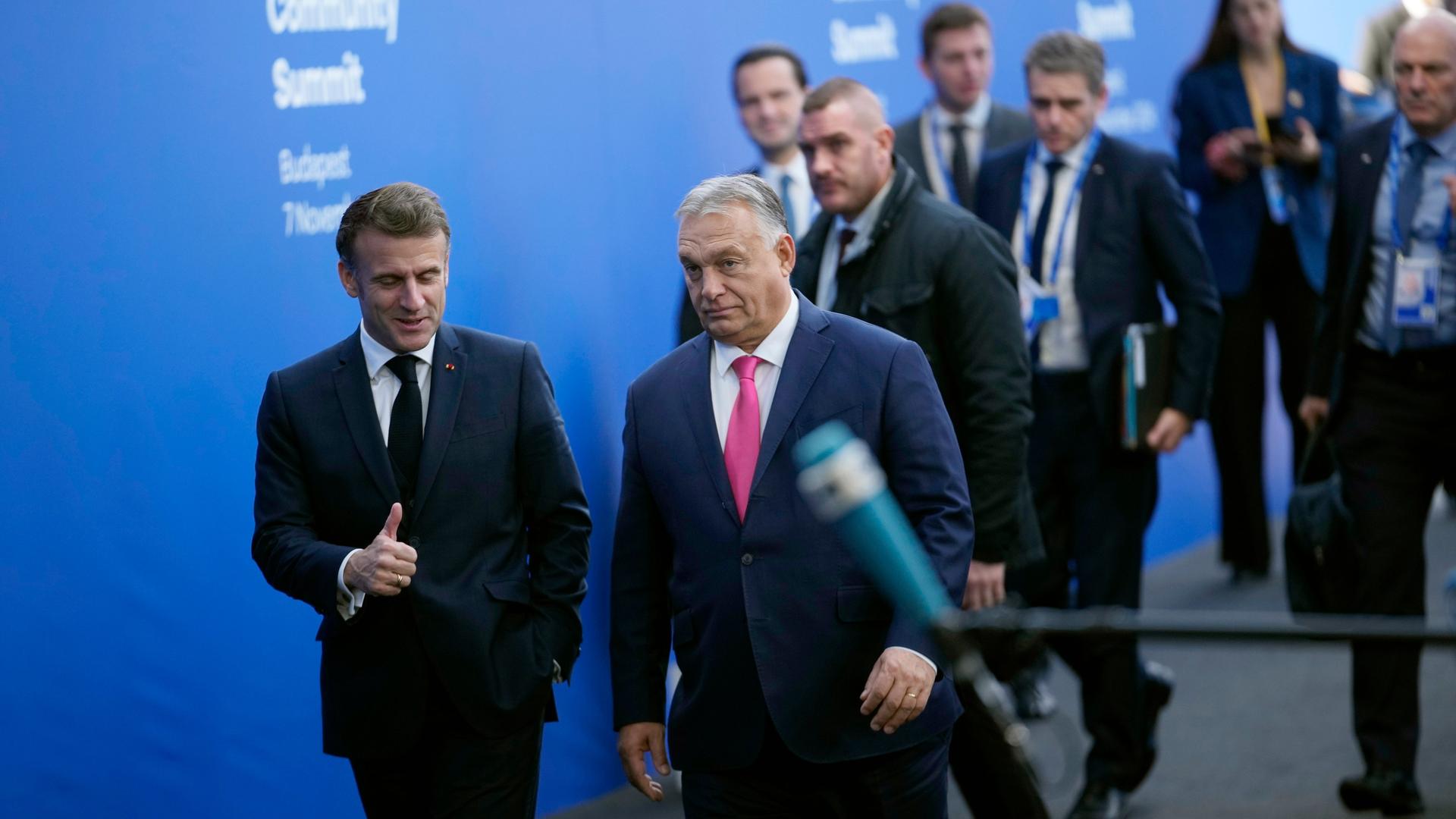 Budapest: Der französische Präsident Emmanuel Macron (l-M) spricht mit dem ungarischen Premierminister Viktor Orban bei seiner Ankunft zum Gipfeltreffen der Europäischen Politischen Gemeinschaft (EPG) in der Puskas-Arena.