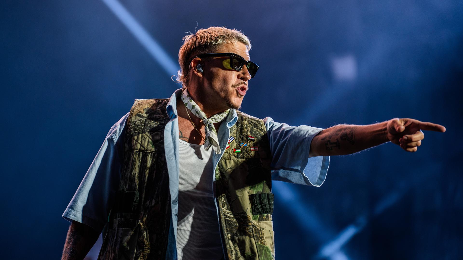 Der US-Rapper Macklemore gestikuliert mit ausgestrecktem Zeigefinger beim dänischen Festival SmukFest 2026 in Skanderborg auf der Bühne.