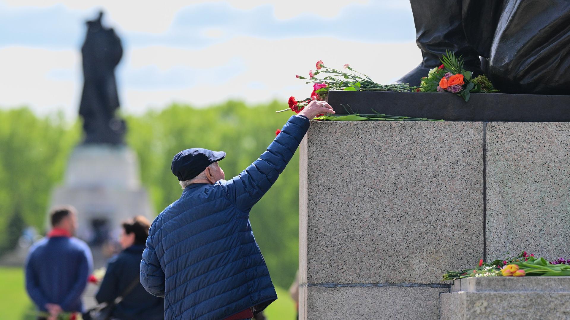Ein Besucher legt am Sowjetischen Ehrenmal Treptow eine Blume nieder.
