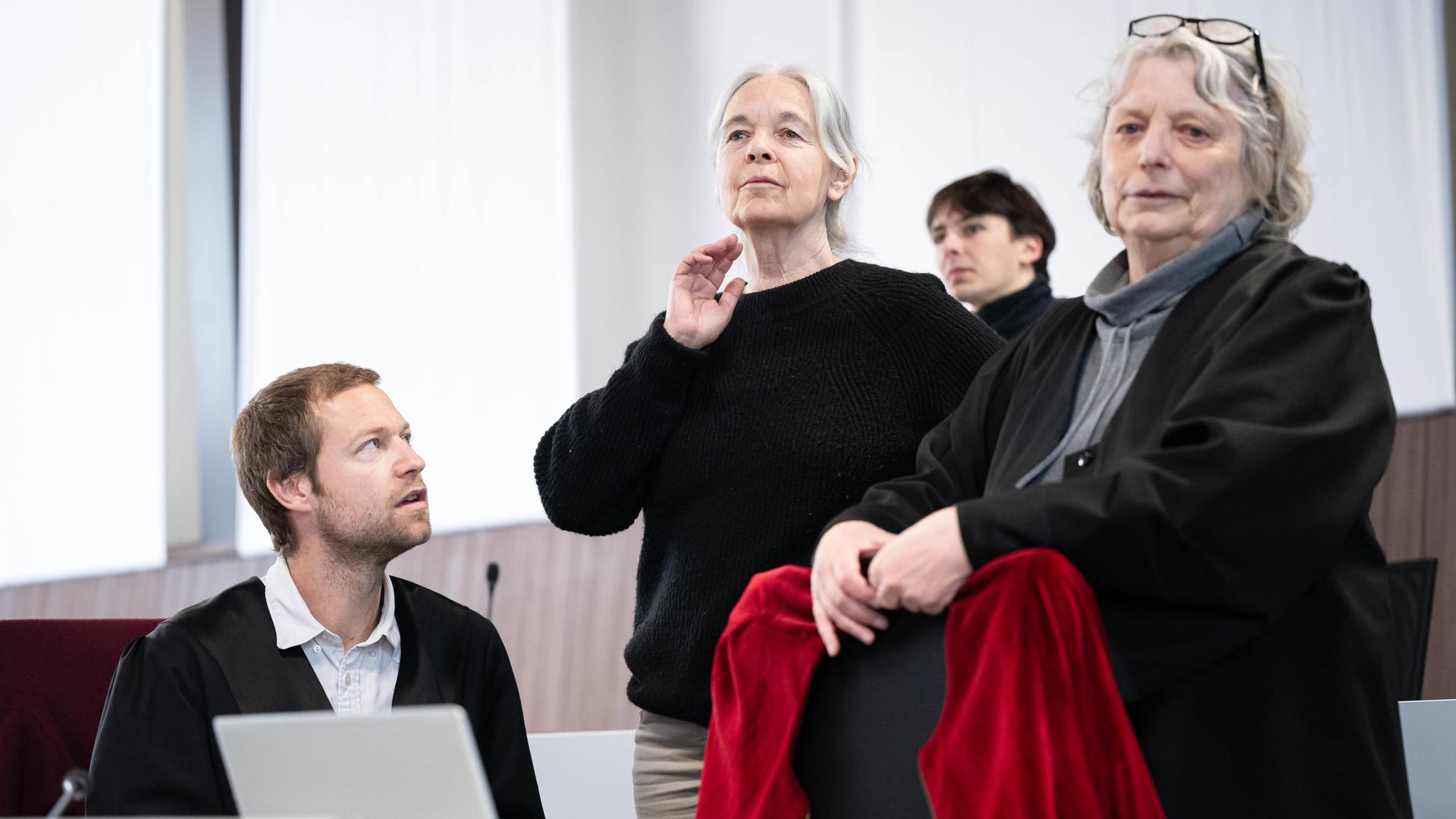 Theune sitzt, Klette und Weyers stehen in dem Raum. Dahinter eine weitere Person.