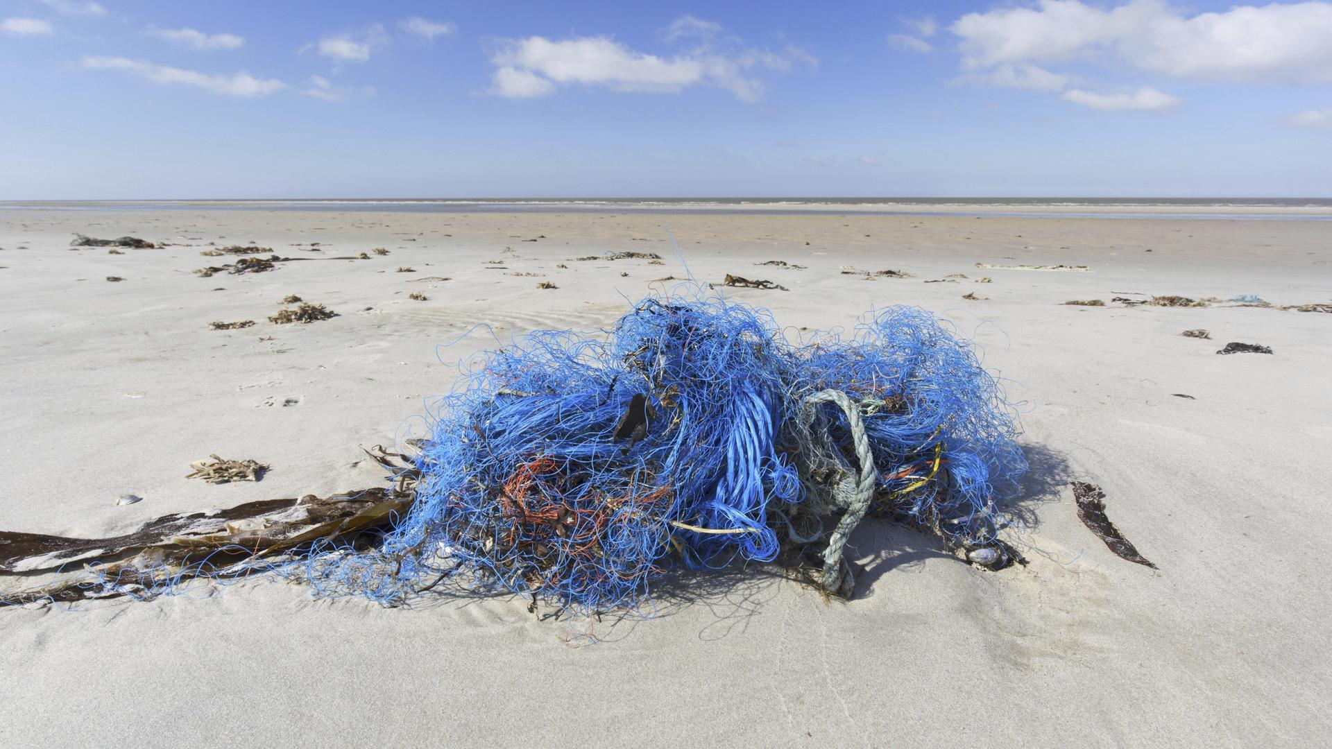 Ein blaues Fischernetz aus Nylon, das an den Strand gespült wurde. 