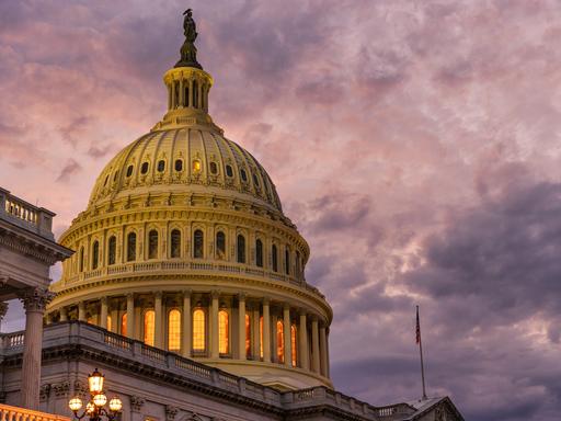 Blick auf das Capitol in den USA - den Sitz des Kongresses, in dem Sitzungen von Senat und Repräsentantenhaus stattfinden. Am Himmel sind düstere Wolken zu sehen. 