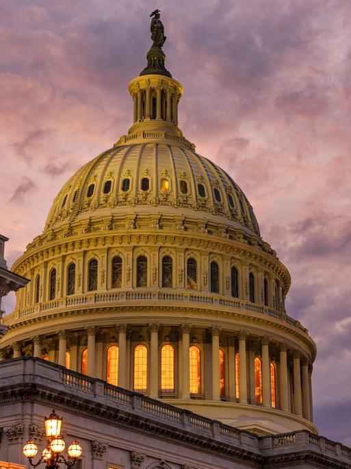 Blick auf das Capitol in den USA - den Sitz des Kongresses, in dem Sitzungen von Senat und Repräsentantenhaus stattfinden. Am Himmel sind düstere Wolken zu sehen. 